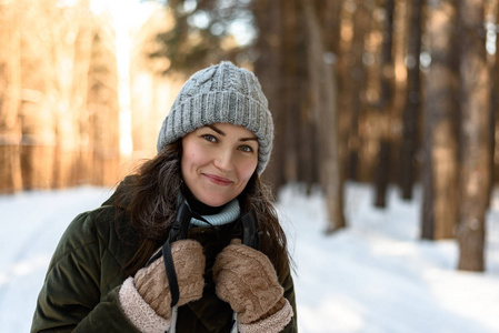 冬天森林里穿冬衣的年轻女人的肖像。 冬天，一个女人在森林里滑雪，爱健康的生活方式，头发上的霜冻