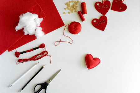 s day felt crafts. Woman hands sewing red hearts. DIY. Flat lay.