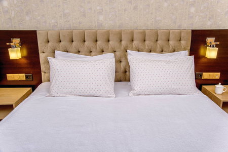 漂亮卧室里的棉床上用品。 白色床上用品，有一个圆圈的图案。 优雅的卧室，柔软的米色床。 枕套和羽绒被盖白色。 酒店卧室