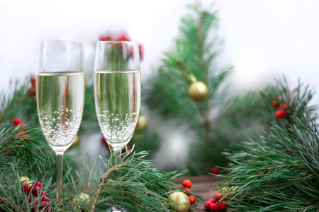 圣诞节和新年的季节组成与松树枝，两杯香槟金球装饰和红罗旺浆果。