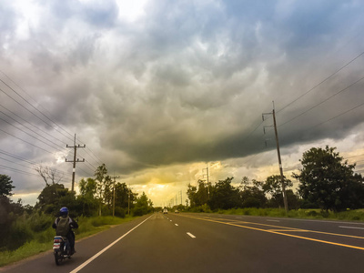 背景是暴风雨天空的沥青道路景观。 高速公路和暴风雨的戏剧性天空背景。