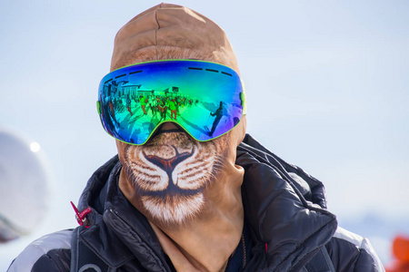 戴着滑雪面具和帽子的面目全非的男人看起来就像滑雪场里的狮子