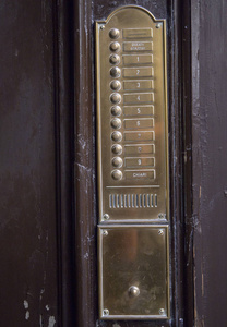老式壁挂式门铃，带有米色石板黄铜纽扣扬声器和铭牌