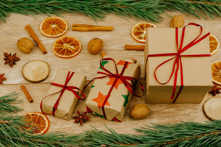 圣诞装饰品。 松枝，肉桂棒，干橘子和礼品盒在木制表面。