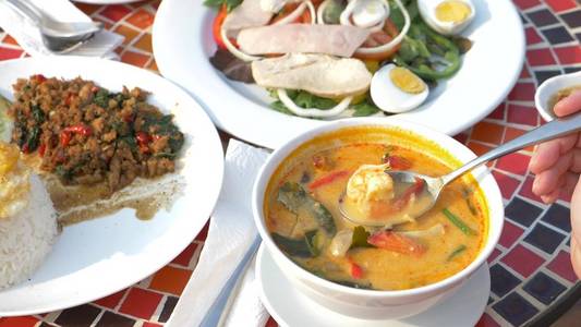 虾辣汤是一种酸辣的泰国菜。有的正在挖虾辛辣汤。特写