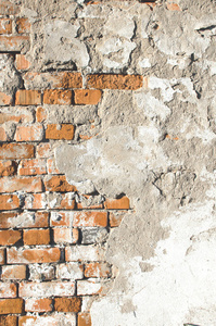 旧的风化砖墙部分覆盖脱落混凝土背景图像