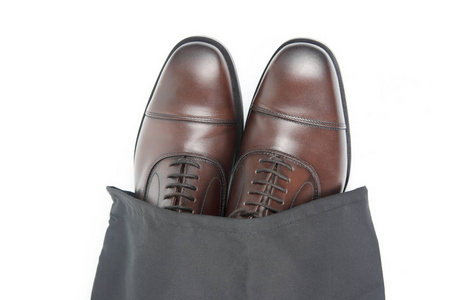 s brown Oxford shoes in protective black pouch on white backgrou
