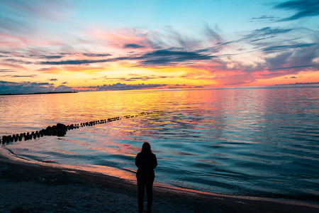 女孩站在海边看美丽的日落