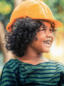 快乐的小男孩工程师戴着黄色的安全帽，带着幸福的笑声。 教育和学习观念。