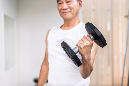 老年人在健身健身房举起哑铃。 老年健康生活方式。