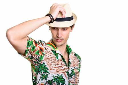 年轻英俊的男人,同时拿着帽子摆姿势的影棚拍摄照片