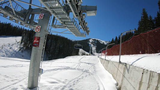 滑雪缆车，座位经过山上，可以看到人们在斜坡上滑雪和滑雪板