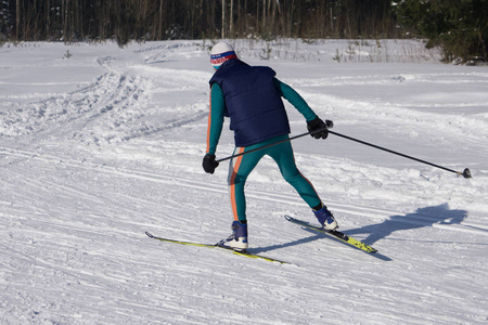 年轻人滑雪者沿着高山的斜坡跑。 冬季运动及康乐休闲户外活动
