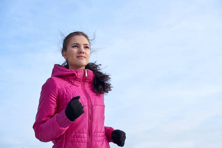跑步运动员女子在寒冷的雪天气下在外面的冬季训练中冲刺。 关闭显示速度和运动。