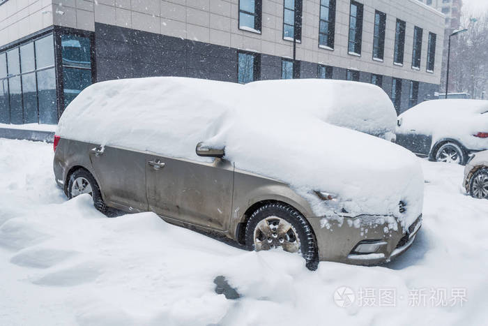 冬天的暴风雪中被雪覆盖的汽车