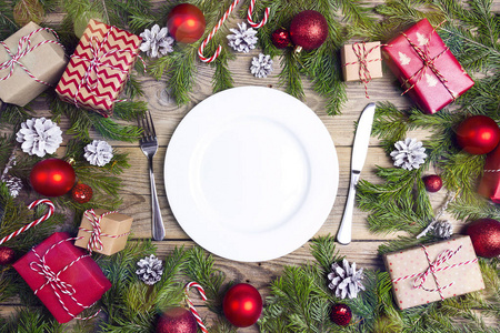 节日餐桌设置与餐具和圣诞装饰品在木桌上。 上面的风景。 圣诞餐具。