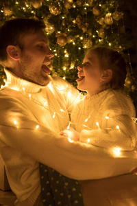 爸爸和女儿在圣诞树上鬼混