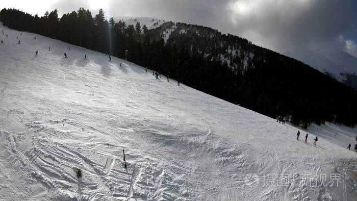 从滑雪缆车到滑雪场的鸟瞰图，在山顶上有大风和大雪漂流