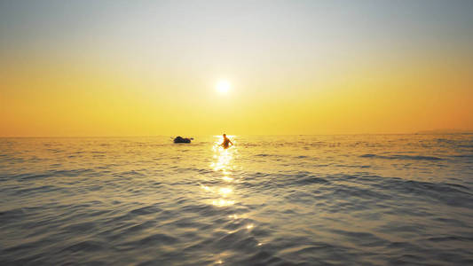 难民们在海上日落时剪影