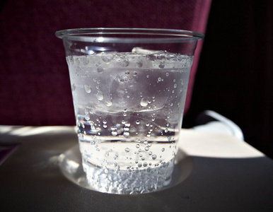 清澈的杯子里冰上的白色火花水