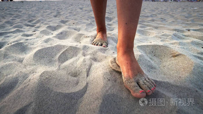 女人走在海滩上,光着脚踩着steadicam射击 年轻女子踩在沙子上的腿