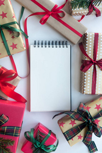 圣诞背景与礼品盒和空白笔记本复印空间。 新年目标模板。 平躺顶部视图。