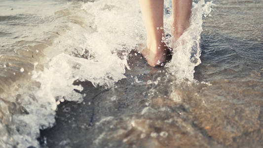 在赤脚的女性脚下行走，溅在海水上，电影中的稳定镜头