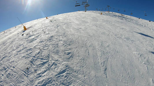 滑雪缆车，座位经过山上，可以看到人们在斜坡上滑雪和滑雪板