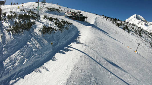 滑雪场斜坡滑雪者在高山峰顶滑滑梯的全景