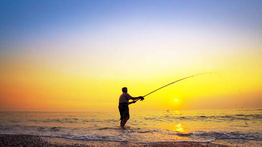 渔翁一位渔翁在海边抛渔钉的剪影照片