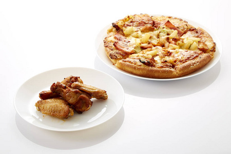 披萨和炸鸡在白色背景上的白色盘子里。