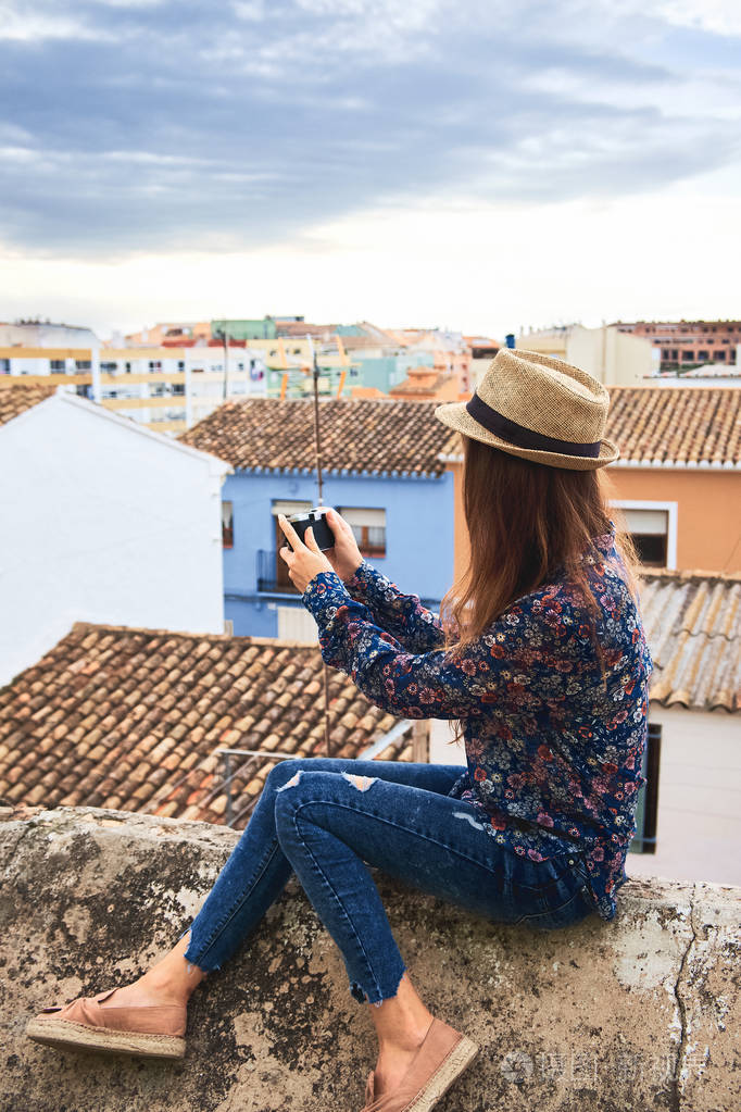 年轻女子用古老的小建筑拍摄西班牙小镇的照片游客欣赏德尼亚镇的景色