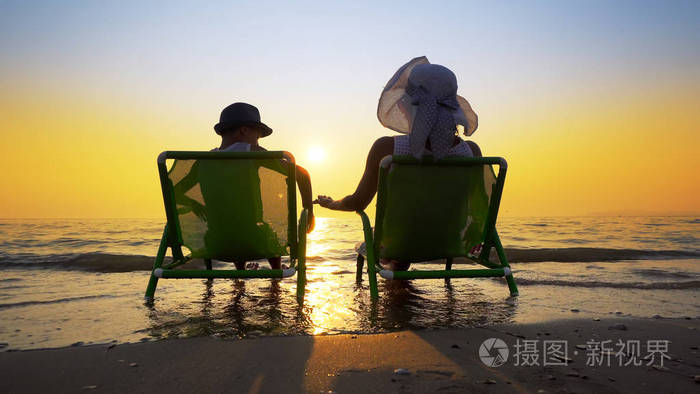 快乐的家庭在暑假期间在海滩上享受豪华的日落母亲和