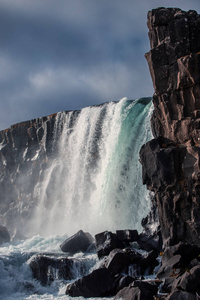 在晴朗的天气下，秋天在冰岛Thingvellir国家公园的雄伟瀑布Oxarfoss