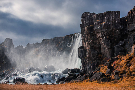 在晴朗的天气下，秋天在冰岛Thingvellir国家公园的雄伟瀑布Oxarfoss
