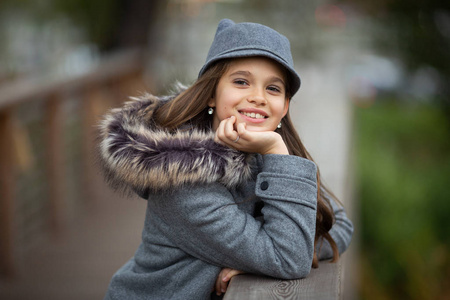 城市木桥上戴着灰色帽子穿着外套的女孩照片