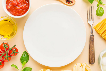 意大利烹饪原料和盘子的顶部视图,明亮的背景照片