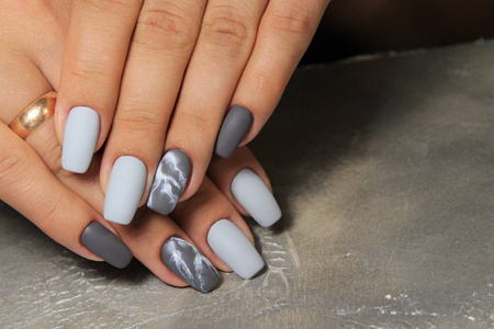 时尚的纹理背景上美丽的灰色闪亮的指甲