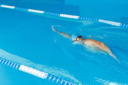 在游泳池中, 身穿蓝帽游泳的运动员形象