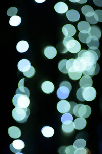 抽象模糊的蓝色和银色闪闪发光的灯泡灯背景模糊的圣诞壁纸装饰概念。圣诞节灯夜抽象圆形的背景。