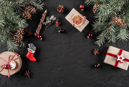 圣诞杉树枝松果礼物在黑暗的背景。 圣诞节和新年主题。 雪。 平躺顶部视图空间文本