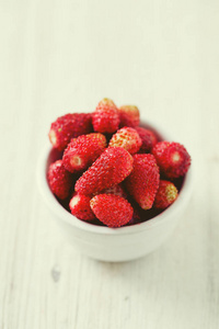 木制表面碗中的野生草莓