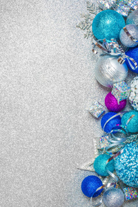 圣诞节装饰彩色闪光球在银色闪光背景与复制空间的文字新年卡概念