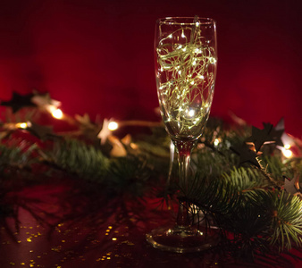 带有花环的酒杯在红色的圣诞节背景上。