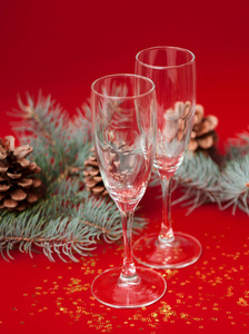 酒杯与圣诞花环红色背景与松树枝。