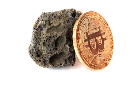 白色背景上的玄武岩岩石和钻头硬币隔离物