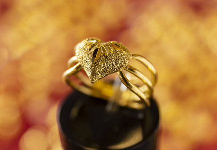 戒指架上的金色心环，背景模糊