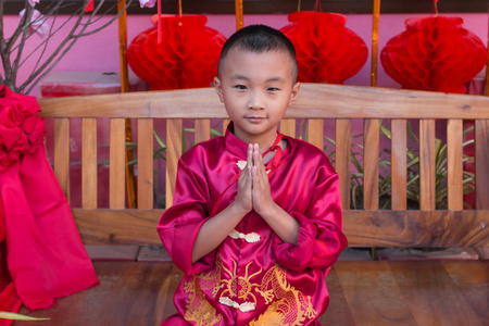 在中国新年庆祝活动中穿红色中国服装的亚洲男孩