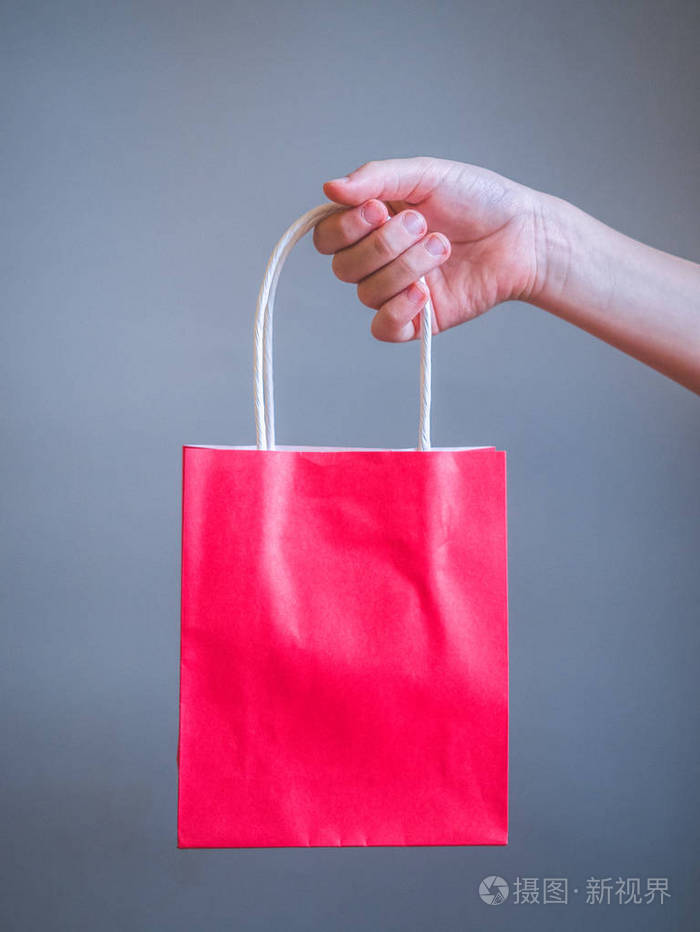 手拿红色袋子作为模型空白模板隔离在灰色背景上