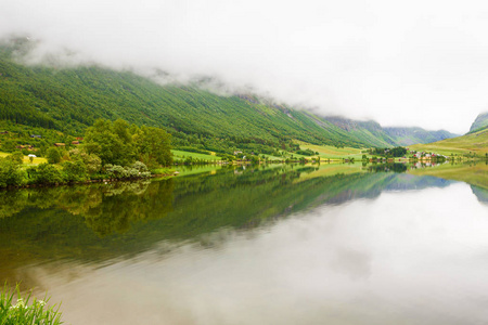 景观与峡湾村和山脉在挪威雾天。